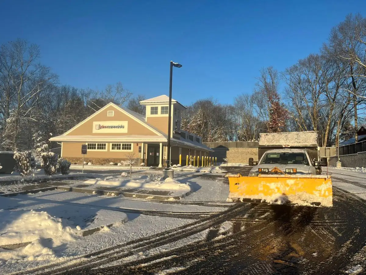 TLC Associates plow truck clearing snow from a commercial property